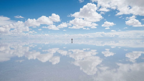 雨季のウユニ塩湖で空と雲が水面に映り込み、天空の鏡のようになった幻想的な風景（南米ボリビア）
