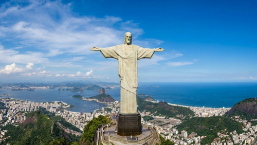 青空の下に立つコルコバードのキリスト像と、リオデジャネイロの街並みと海を一望できる絶景パノラマ