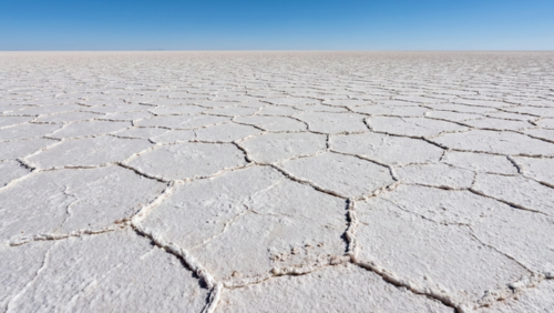 乾季のウユニ塩湖、幾何学的な六角形模様が広がる白い大地。人物なし。