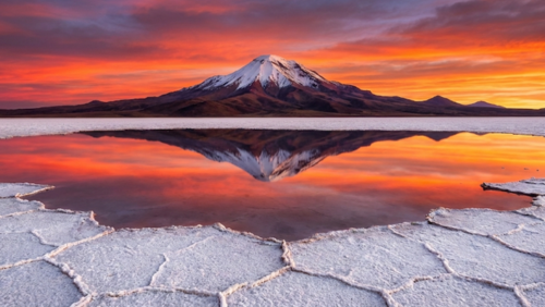 ウユニ塩湖北部にそびえるトゥヌパ火山、塩湖に映り込む神秘的な景色。人物なし。