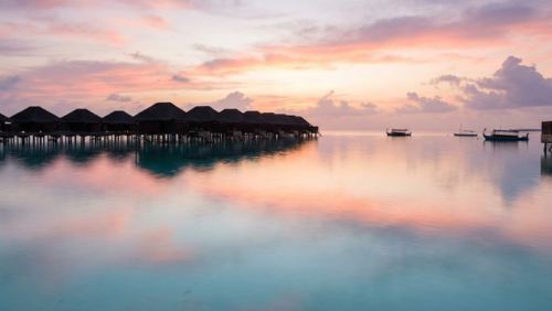 朝焼けに染まる北マーレ環礁の海と水上ヴィラ。静かなモルディブの朝