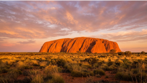 朝日に照らされて赤く輝くオーストラリア・ウルルと広大なアウトバックの風景