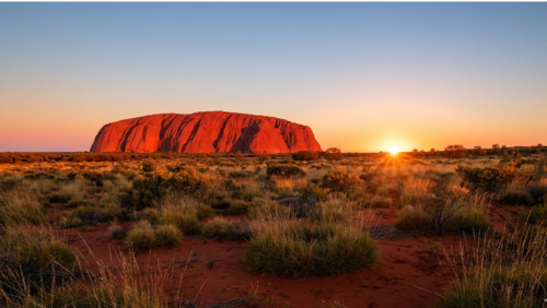 朝焼けに照らされて赤く輝くオーストラリア中央部のウルル