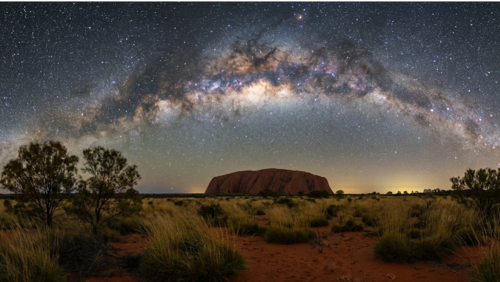 満天の星空と天の川の下にそびえるウルルの夜景