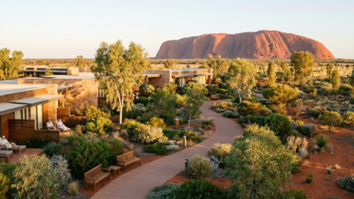デザート・ガーデンズ・ホテルの庭園越しにウルルが見える、自然と調和した落ち着いたリゾート風景
