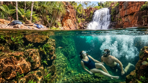 オーストラリアのリッチフィールド国立公園にある、透明度抜群なフローレンス滝の水中写真です。赤褐色の巨大な砂岩の絶壁から流れ落ちる滝（ image_197.png）を、澄んだ水中から見上げるアングルで捉えています。水面には太陽光が差し込み、美しい光の筋（caustics）がエメラルドグリーンの水中を照らしています。水中では、以前のアクーブラハットを被ったカップル（ image_187.png の人物）が、水中に浮いて微笑み合いながら、澄んだ水を共有しています。女性（30代、ダークヘア、ネイビーの水着）と男性（30代、髭）は、水中ゴーグル（ mask/snorkel）を着用しています。滝つぼの底には、滑らかな赤砂岩の岩、澄んだ砂、そして小さなネイティブの淡水魚（虹色に光る魚やテトラ）が泳いでいるのが見えます。滝つぼの縁（水面近く）には、以前のアクーブラハット（ image_117.png のスタイル）が、滝つぼを囲む緑豊かな熱帯雨林（パンダナス、シダ、ユーカリ）に面した濡れた岩の上に置かれているのが見えます。太陽光は水面を透過し、水中を明るく照らしており、滝の落ちる白い泡と、水面の波紋、そして水中の光の筋が複雑に絡み合っています。水中の岩の質感、人物の肌の質感、ゴーグルの反射、泳ぐ魚の動き、そして滝の泡のディテールが鮮明に描写されている高解像度8K水中写真です。