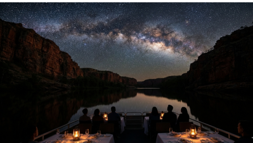 オーストラリア・ニトミルク渓谷を静かに進むナイトクルーズ。両側にそびえる巨大な断崖のシルエットと、夜空に広がる天の川や満天の星が、鏡のような水面に美しく反射している。暖かなランタンの灯りがともるテーブル席で、乗客たちが静かに星空を見上げる、神秘的でロマンチックな夜景写真