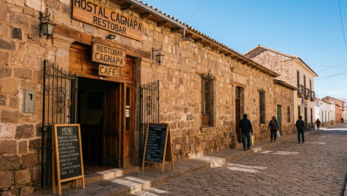 ウユニ中心部にあるホスタル・カグナパ・レストバーの外観。伝統的なアンデス風建築と落ち着いた色合いの石壁、入口にカフェ・バーの看板が見える。