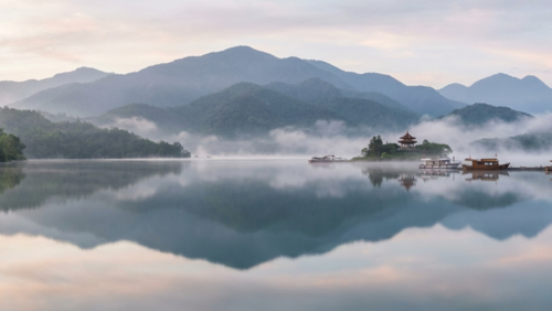 朝霧に包まれた日月潭。湖面に山々が映る静かな絶景。