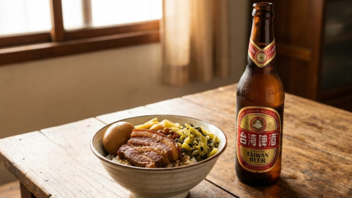茶碗に盛られた甘辛く煮込んだ豚肉の魯肉飯（ルーローファン）の横に、台湾ビールの瓶が置かれている。食欲をそそる角度で撮影され、温かみのある自然光で豚肉の色やご飯の質感がはっきり見える横長の画像