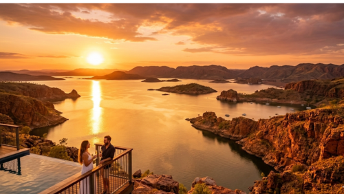 アーガイル湖を見下ろす高台にある、ディスカバリーリゾーツのインフィニティ・プールとテラス。沈みゆく大きな太陽が空と湖面、そして周囲の切り立った赤い岩山を鮮やかな黄金色に染め上げている。手前のデッキでは、カップルがグラスを手に絶景を眺めながら語り合っており、静寂に包まれた贅沢な「ゴールデンアワー」のひとときを捉えた風景写真