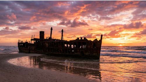 夕焼けに染まる砂浜に佇むマヘノ号の幻想的な風景