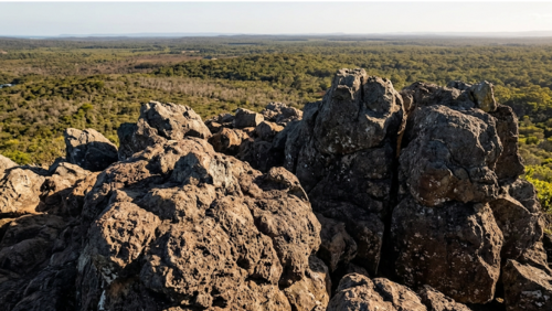 エミューマウンテン山頂の岩場の風景。火山活動で形成された独特な形の岩が広がる自然の景色