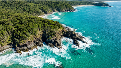 ヌーサ国立公園の海岸線の絶景。エメラルドブルーの海と緑の断崖が広がる風景