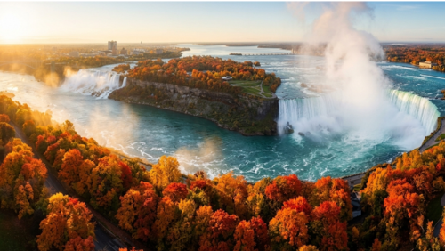 真っ赤や黄金色に染まった紅葉に囲まれる秋のナイアガラの滝の絶景。ホースシュー滝から立ち上る白い水しぶきと、赤・オレンジ・黄色に輝くメープルの木々が広がる幻想的な超高精細風景写真